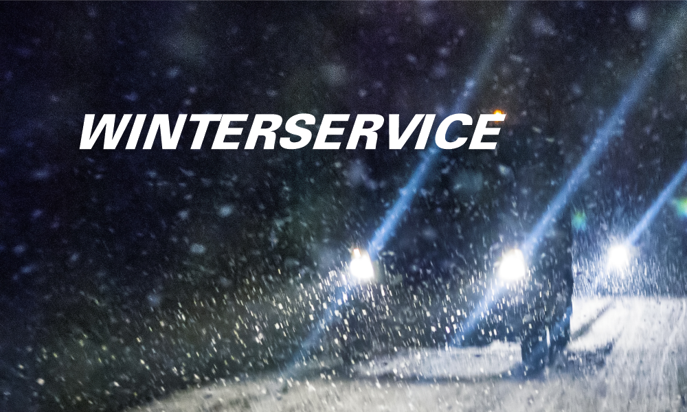 Fahrzeuge auf eingeschneiter Straße