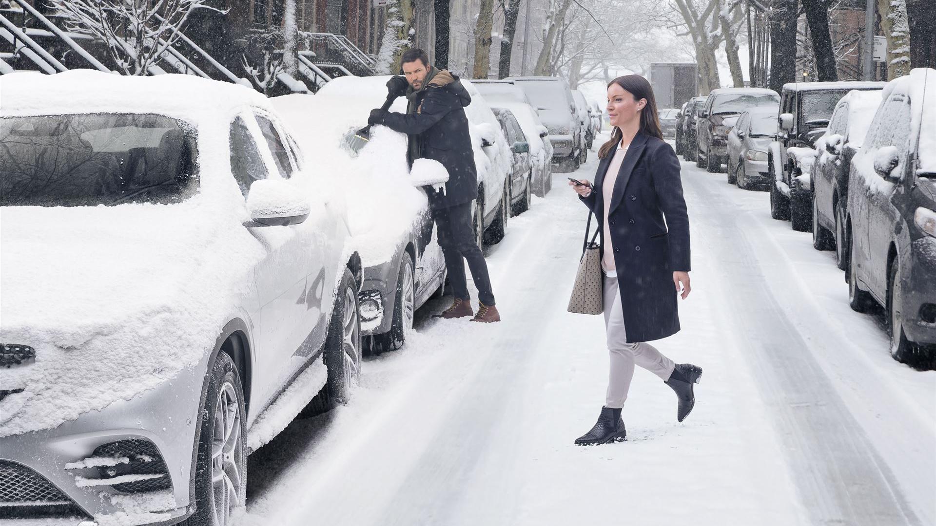 zugeschneite Straße mit eingeschneiten parkenden Autos links und rechts